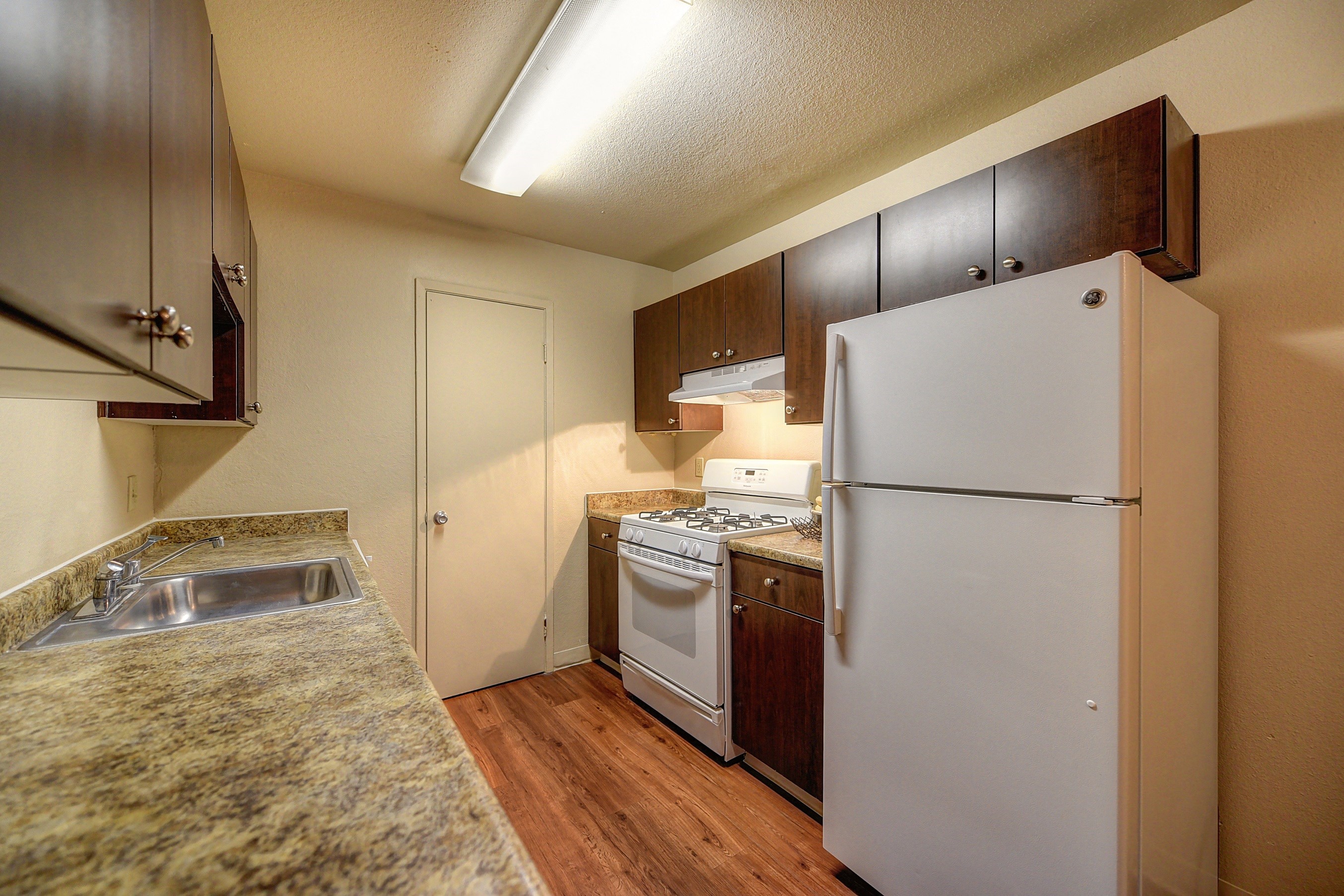 Kitchen with Granite Quartz Countertops, Hardwood Inspired Floors, Wood Cabinets, Refrigerator/Freezer, Oven, Stove